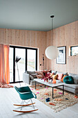 Bright living room with wood panelling and colourful accent cushions