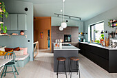 Modern kitchen with cooking island, bar stools and adjoining seating area