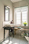 Bright bathroom with free-standing washbasin and patterned floor tiles
