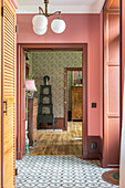 Hallway with pink tones, patterned leopard wallpaper and tiled floor