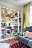 Living room with bookshelf, blue-grey sofa and oriental rug