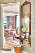 Hallway with console and mirror, view into the dining room with chandelier