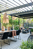 Terrace with modern furniture and woven lamp under pergola