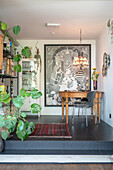 Wooden table with grey chair and large work of art on the wall