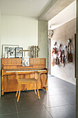 Wooden piano and wall with leather bags in the entrance area