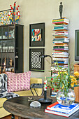 Book tower, yellow sofa and wall art