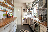 Kitchen with wooden worktops, patterned tiles and door with porthole