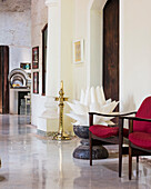 Foyer with large flower sculpture, red armchair and stone floor