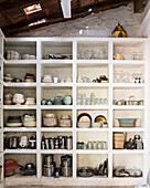 Shelf with rustic crockery and kitchen utensils in rustic kitchen