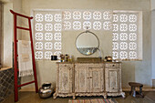 Badezimmer mit geschnitztem Holzwaschtisch und dekorativen Mauersteinen