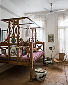 Bedroom with wooden four-poster bed in Asian style