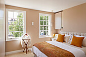 Sun shining through transom windows into the classic bedroom