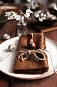 Easter place setting with brown cloth napkin, chocolate Easter bunny and quail egg