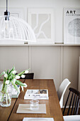 Dining area with wooden table, chairs and pictures on picture rail