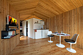 Modern chalet with wood paneling and tulip chairs