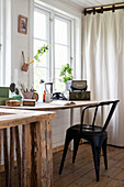 Rustic wooden work desk with black chair and vintage accessories