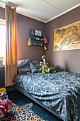Bett in Jungemzimmer mit gedeckter Wandfarbe