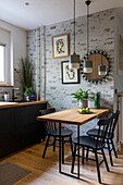 Kitchen with black cupboards; dining table with black chairs
