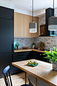 Corner kitchen with black and light wood-tone cupboards
