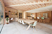 Moderner offener Wohnraum mit Holzbalkendecke und Backsteinwand