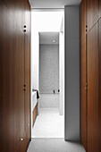 Wardrobe with floor-to-ceiling fixtures, view into the bathroom