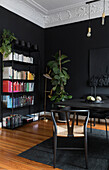 Bookcase in room with both black table and walls
