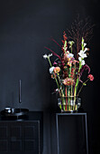 Bouquet on small table in front of black wall