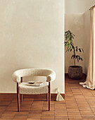 Sessel vor weißer Wand auf Backsteinboden im minimalistischen Stil