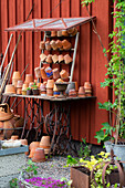 Terracotta pots on a covered potting bench made out of old sewing machine table