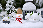 A mini snowman on a planting table
