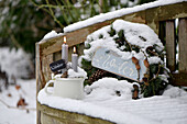 A winter wreath on a snow-covered garden bench