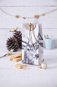 A homemade gift bag with a deer motif made from a recycled milk carton