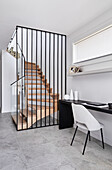 An entrance and a stairway of a modern home with a study nook next to the stairs