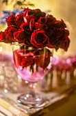 A bouquet of red roses in a glass