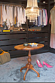 Walk-in closet with crystal chandelier and pedestal table