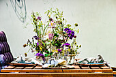A table laid on a summer terrace decorated with wild flowers
