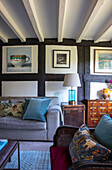 Gemälde über Sofa und antike Möbel im Wohnzimmer mit Fachwerkwand