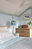 Double bed and chest of drawers in the bedroom in light blue and white