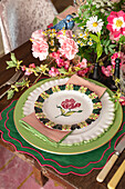 Gedeck auf Tisch mit üppiger Blumendekoration