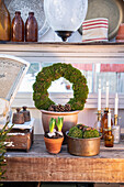 Plant pots, wreathes, and candles next to old kitchen scales