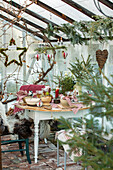 Gedeckter Tisch im Gewächshaus mit Weihnachtsdekoration