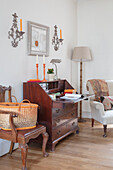 Antique secretary desk, above it wall candlestick sconces in the study