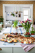 Various pastries, strawberries, and bouquet of tulips on a kitchen island