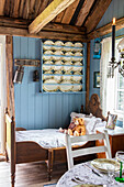 Tellerboard an blauer Wand über Kinderbett in einem Cottage