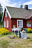 Red painted Swedish cottage with patio area