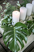 DIY Advent wreath made of leaves, with white pillar candles