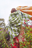 Young woman with green and white checked merino blanket