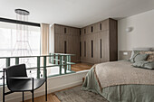 Open bedroom with queen bed and floor-to-ceiling closets in a maisonette flat