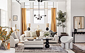 Graues Sofa mit Kissen, Ottoman, runder Tisch und Designersessel in hellem Wohnzimmer