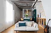 Open living space with exposed ceiling beams in a loft
